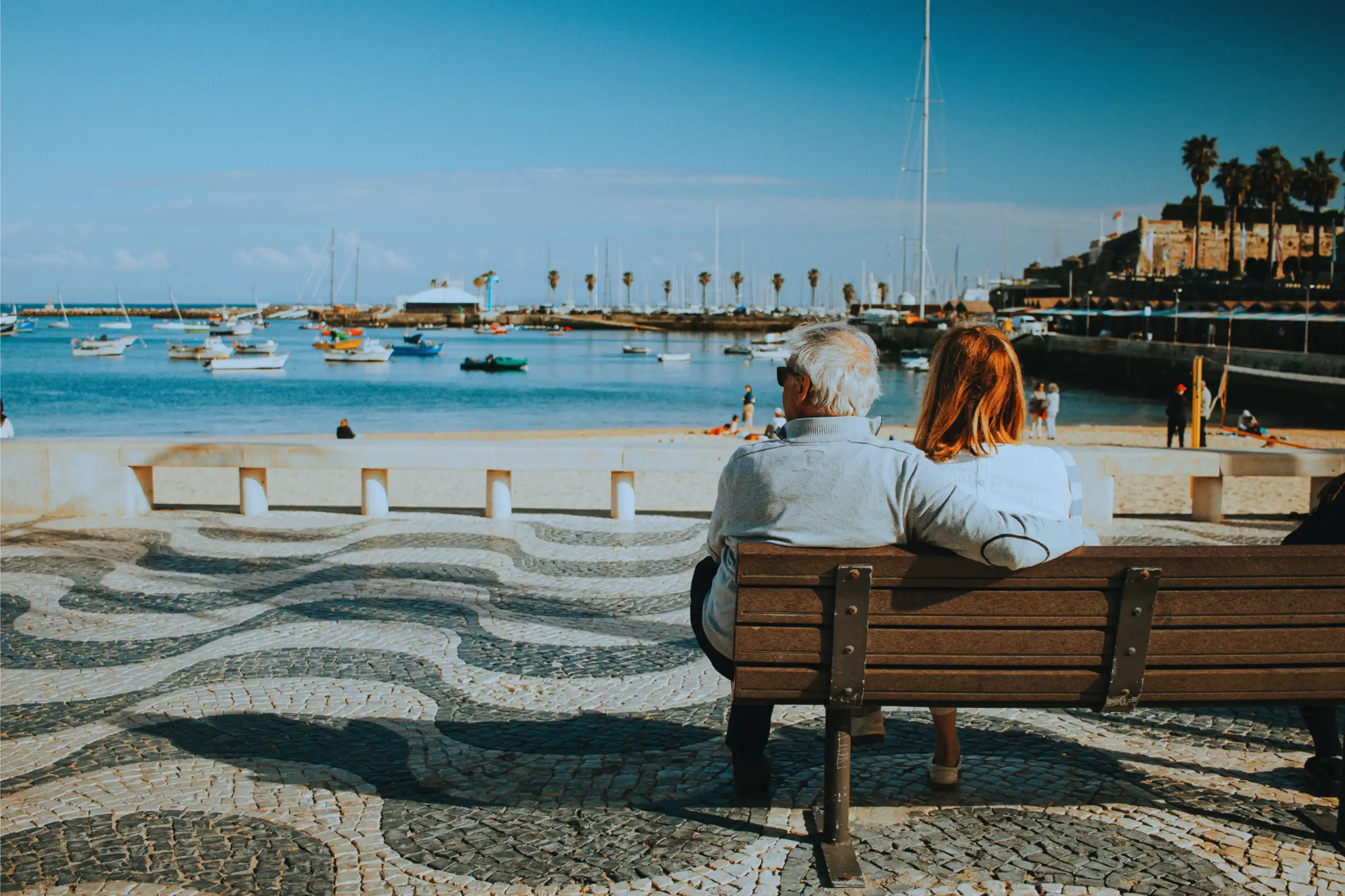 Senior couple sitting on a seaside bench enjoying retirement